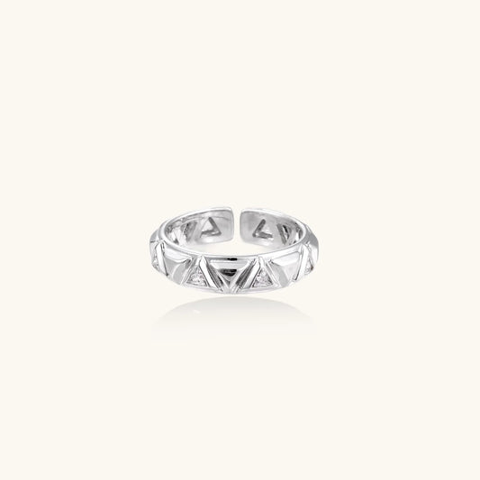 White gold adjustable ring with geometric triangle cutouts and zirconia stones on cream background