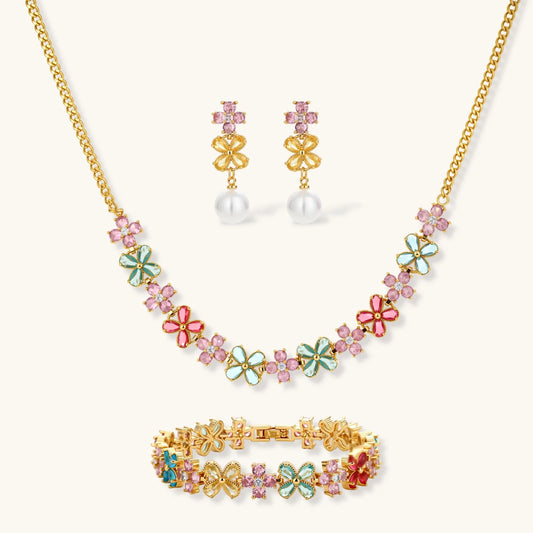 Gold-plated jewelry set with pink, turquoise and red flower-shaped cubic zirconia stones, featuring necklace, earrings and bracelet.