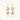 Gold sunburst charm earrings with baroque pearl drops on French hooks against cream background