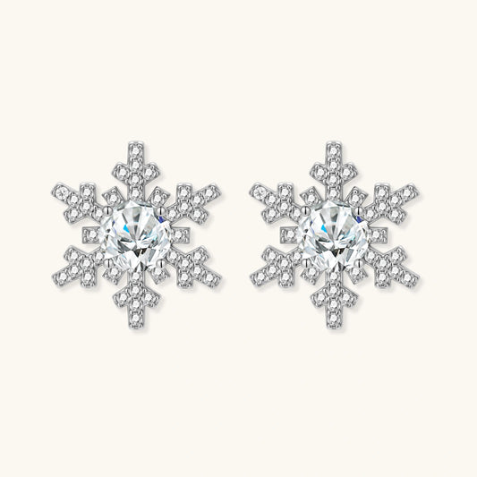 Sterling silver snowflake stud earrings with brilliant moissanite centers and intricate geometric patterns on cream background