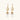 Gold sunburst charm earrings with baroque pearl drops on French hooks against cream background