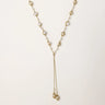 Adjustable gold lariat necklace with freshwater pearls nested in delicate cage settings and Y-shaped tassel drop