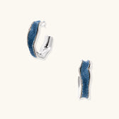 Silver huggie hoops with blue denim fabric inlay strip and polished white gold plated finish on cream background.