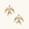 Gold-plated brass earrings shaped as doves in flight with lavender zirconia oval stones at center and textured wing details
