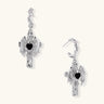 Silver-toned drop earrings with angel wings framing a black heart-shaped stone, white gold plated brass with S925 posts