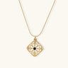 Gold filigree pendant with quatrefoil design, deep blue lapis lazuli center, clear crystal accents on ball chain