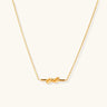 Dainty 18K gold plated necklace with infinity knot pendant on delicate chain against white background