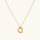 Delicate gold-plated necklace with three interlocking circle rings forming a minimalist knot pendant on cream background