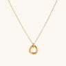 Delicate gold-plated necklace with three interlocking circle rings forming a minimalist knot pendant on cream background