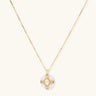 Gold-plated necklace with circular white enamel pendant featuring central zirconia stone and ornate decorative details