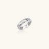 White gold adjustable ring with geometric triangle cutouts and zirconia stones on cream background