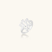 Sculptural sterling silver ring with organic branch design and textured surfaces on cream background