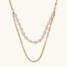 Layered gold chain necklace with organic baroque freshwater pearls and adjustable length on cream background