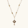 Y-shaped necklace with freshwater pearls, gold filigree stations, and ornate diamond-shaped centerpiece with pearl drop